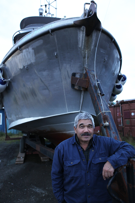 Robert Heyano standing next to Lady Mindy, his fishing boat. Photo credit: Duncan Sullivan